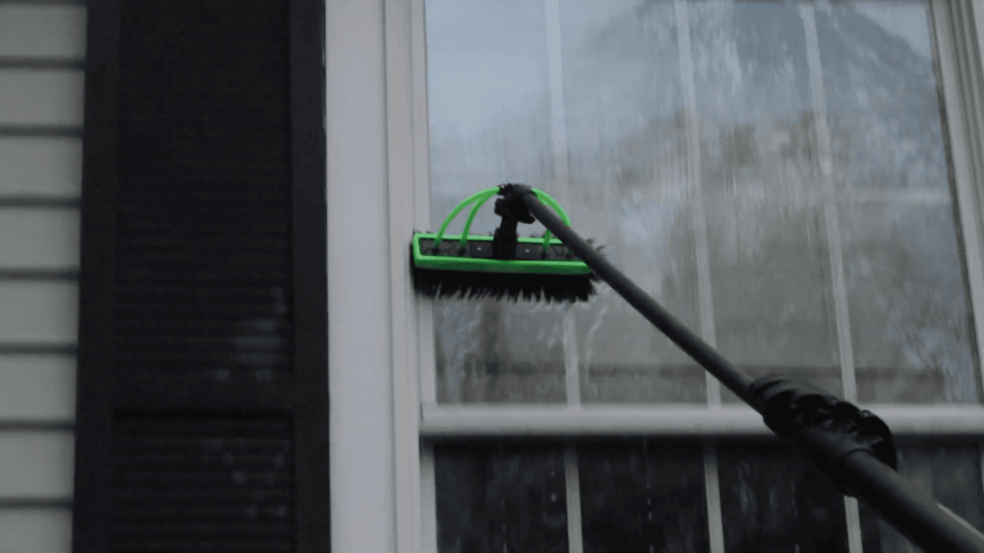 Pure-water brush scrubbing soap solution across glass